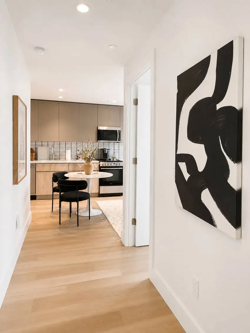 Gallery hallway with art leading into dining and kitchen