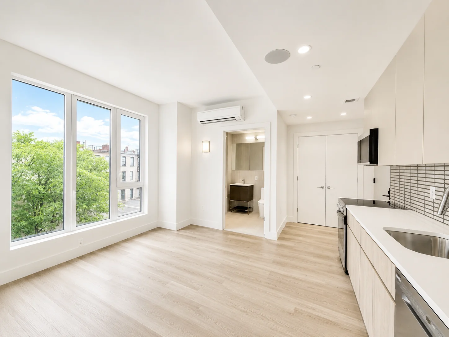 Residence 601 living area with windows and kitchen view